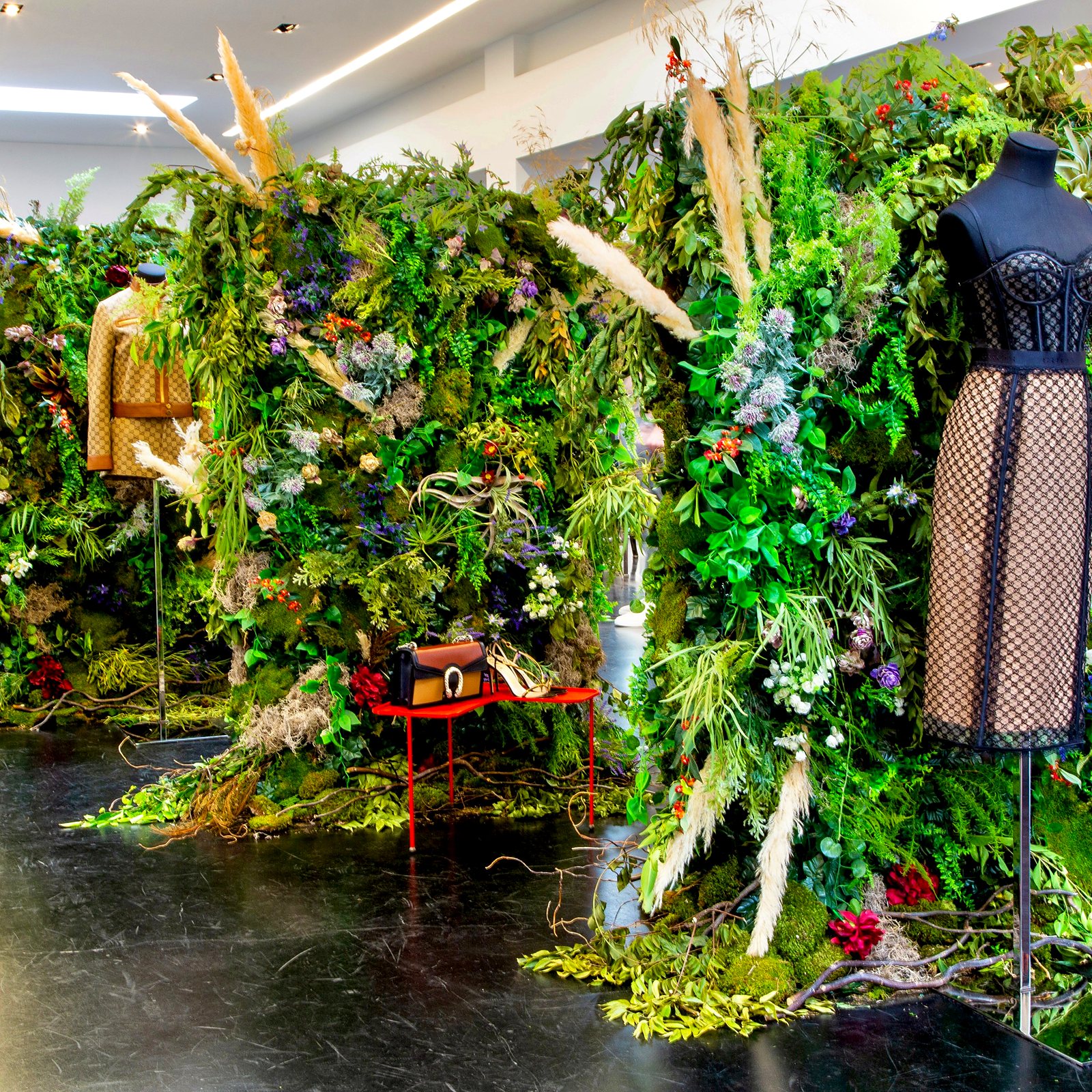 Lush greenery wall with pampas grass and wildflowers in a luxury fashion boutique